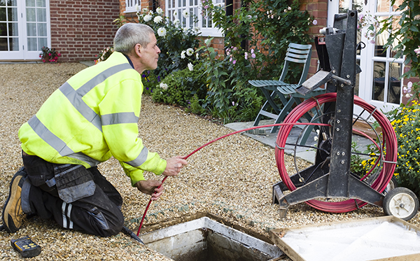 Man unblocking outside drain