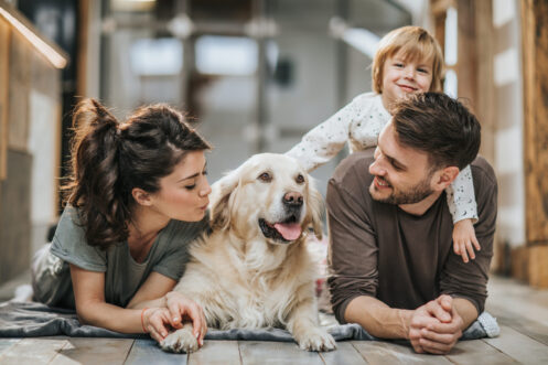 Young family relaxing with their dog at home in San Antonio.